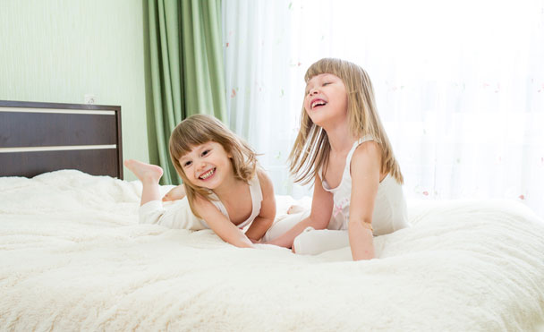 two small children playing on mattress